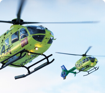 Two Scotland Charity Air Ambulance Helicopters flying in the blue sky